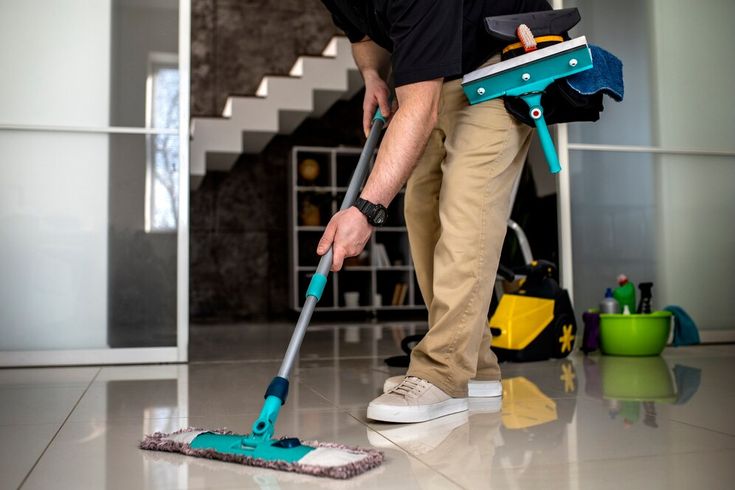 Man wiping the floor with mop