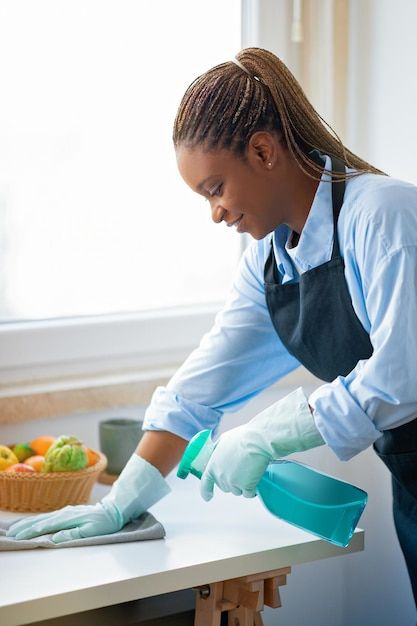 Cleaning lady wiping the top of a table surface